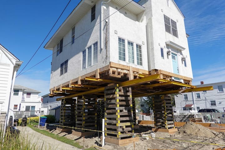 A team of professionals using specialized equipment to raise a house in Jefferson City, preparing it for elevation and renovation